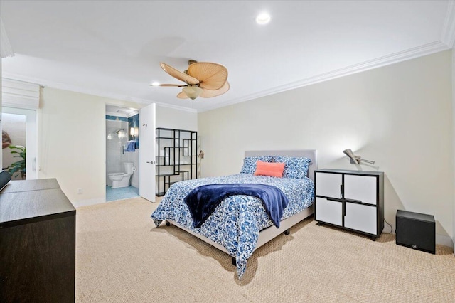 bedroom with ceiling fan, light colored carpet, crown molding, and ensuite bath