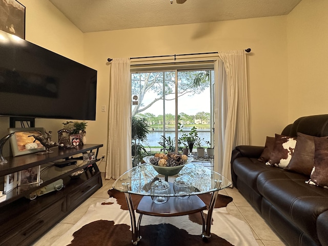 tiled living room featuring a water view and a textured ceiling