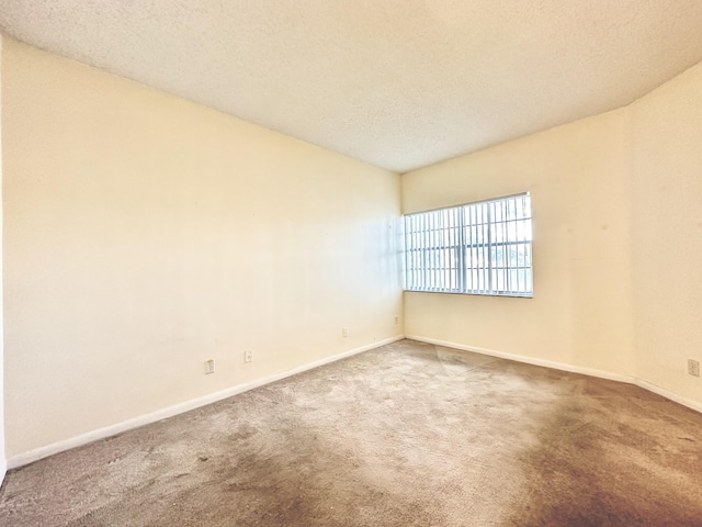 unfurnished room featuring carpet floors and a textured ceiling