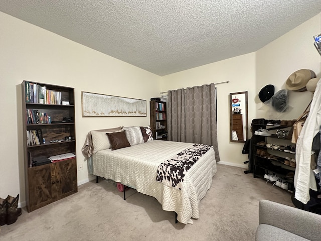 bedroom with light carpet and a textured ceiling