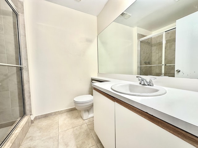 bathroom with tile patterned floors, vanity, toilet, and walk in shower