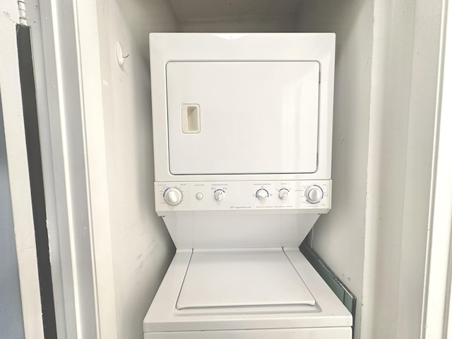 washroom featuring stacked washer and clothes dryer