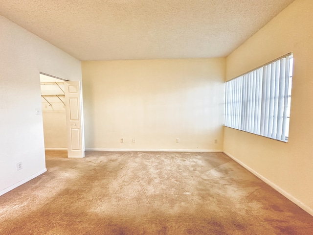 unfurnished room featuring carpet flooring and a textured ceiling