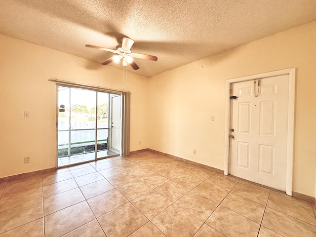 spare room with ceiling fan, light tile patterned floors, and a textured ceiling