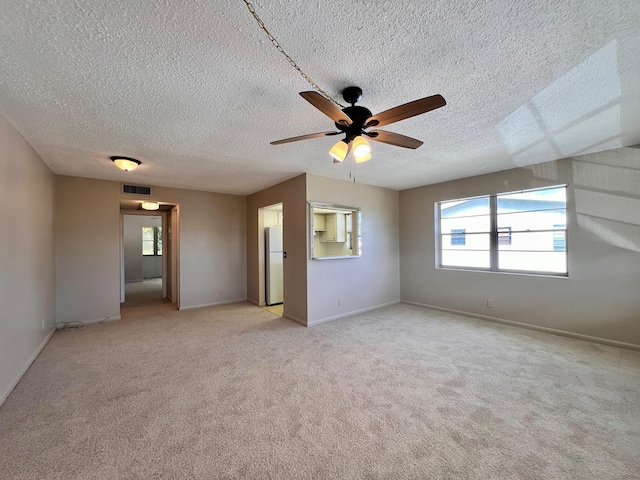 carpeted spare room with ceiling fan and a textured ceiling