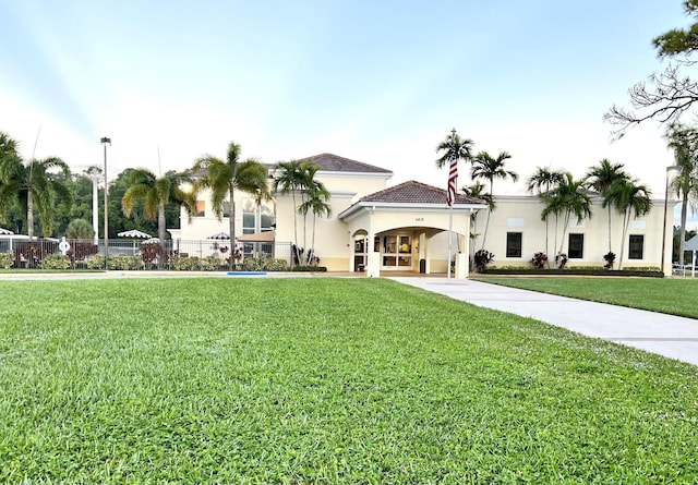 exterior space with a tiled roof, a front lawn, and stucco siding