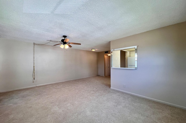 carpeted spare room featuring ceiling fan and a textured ceiling