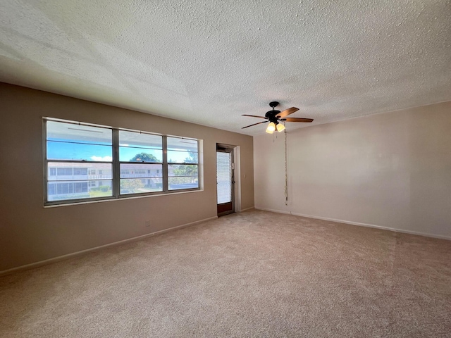 unfurnished room with baseboards, a textured ceiling, a ceiling fan, and light colored carpet