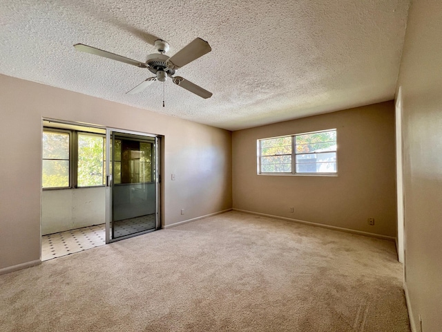 unfurnished bedroom with carpet floors, ceiling fan, baseboards, and a textured ceiling