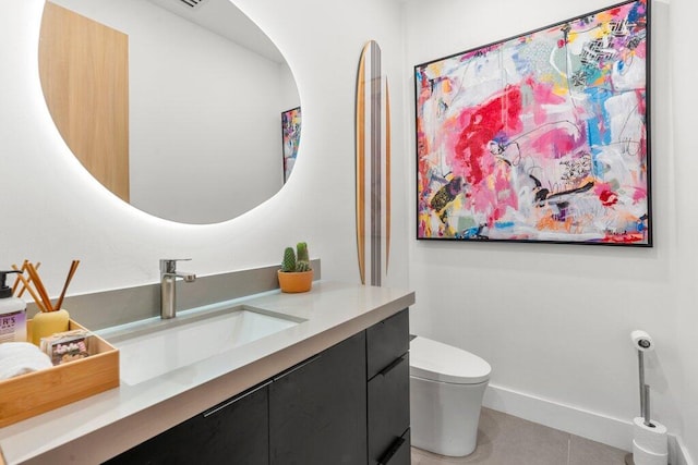 bathroom with tile patterned flooring, vanity, and toilet