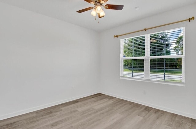 empty room with a wealth of natural light, ceiling fan, and light wood-type flooring