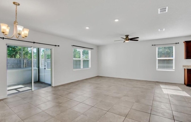 unfurnished room featuring ceiling fan with notable chandelier and light tile patterned floors