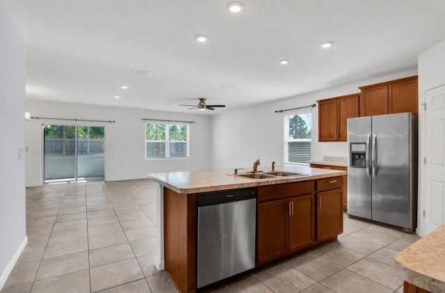 kitchen with ceiling fan, sink, a center island with sink, light tile patterned floors, and appliances with stainless steel finishes