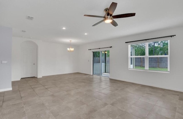 empty room with light tile patterned floors and ceiling fan with notable chandelier