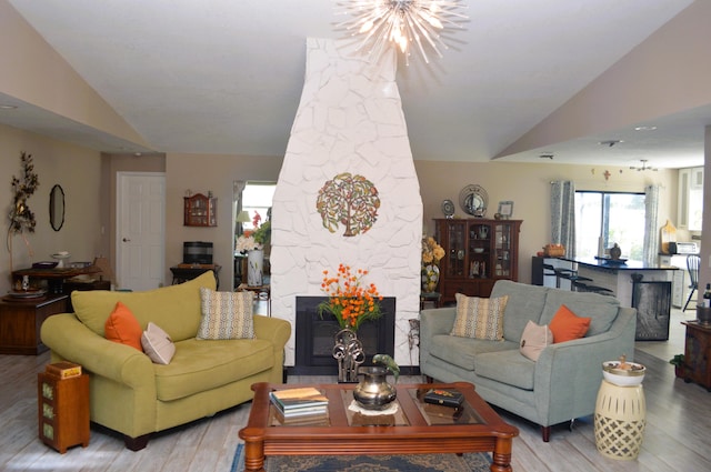 living room featuring light hardwood / wood-style floors, lofted ceiling, and an inviting chandelier