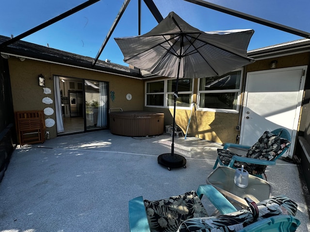 view of patio / terrace with glass enclosure and a hot tub