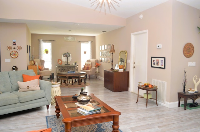 living room with a chandelier and light hardwood / wood-style floors