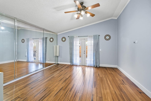 spare room featuring vaulted ceiling, a textured ceiling, and french doors