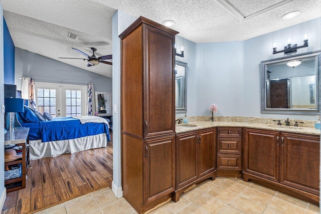 interior space featuring ceiling fan, light wood-type flooring, a textured ceiling, and vaulted ceiling