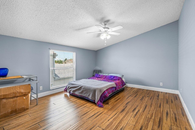 bedroom featuring hardwood / wood-style floors, a textured ceiling, and ceiling fan