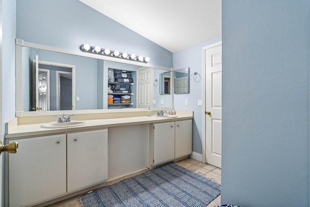 bathroom with tile patterned floors, vanity, and vaulted ceiling