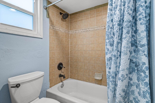 bathroom with a textured ceiling, toilet, and shower / tub combo with curtain