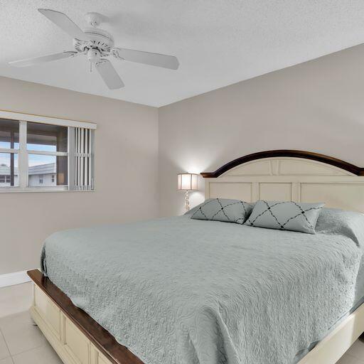 tiled bedroom with ceiling fan