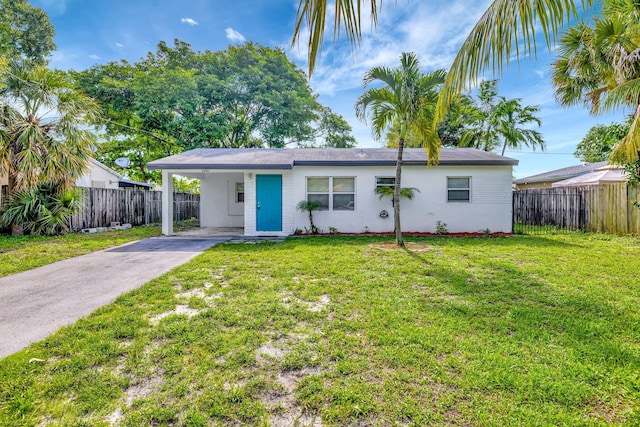 ranch-style house with a carport and a front lawn