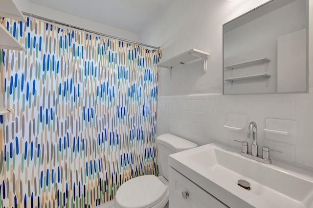 bathroom with vanity, curtained shower, toilet, and tile walls