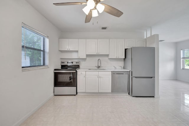 kitchen featuring ceiling fan, sink, white cabinets, and stainless steel appliances