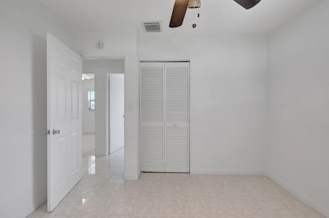 unfurnished bedroom featuring ceiling fan and a closet