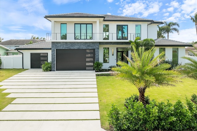 view of front of house with a balcony, a front yard, and a garage