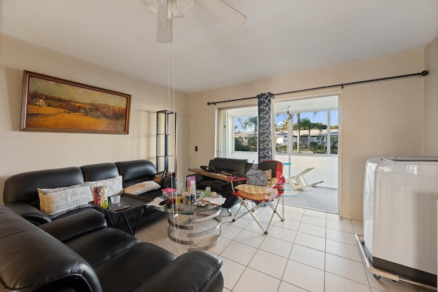 tiled living room with ceiling fan, a textured ceiling, and washing machine and clothes dryer