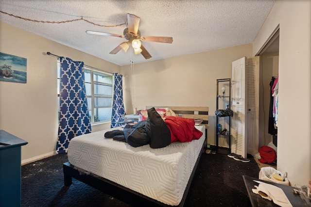 bedroom with dark colored carpet, a textured ceiling, and ceiling fan