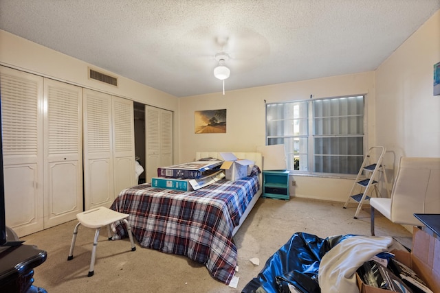 carpeted bedroom with ceiling fan and a textured ceiling