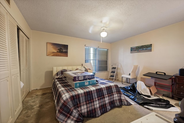 bedroom featuring a textured ceiling, a closet, dark carpet, and ceiling fan