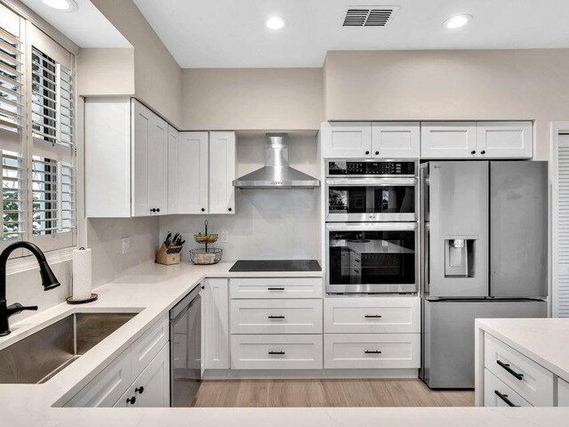 kitchen with white cabinets, decorative columns, and a wealth of natural light