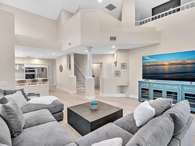 living room with a high ceiling and light wood-type flooring