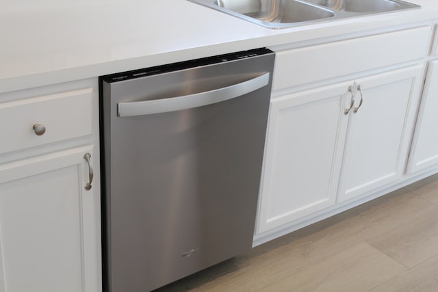 kitchen featuring white cabinets, stainless steel dishwasher, and sink