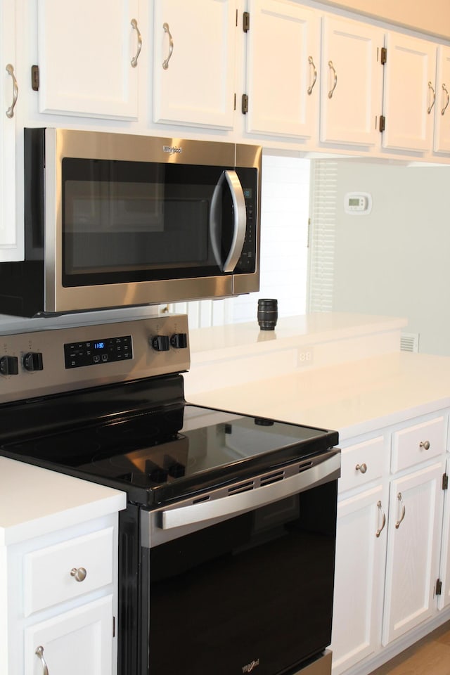 kitchen with white cabinets and appliances with stainless steel finishes