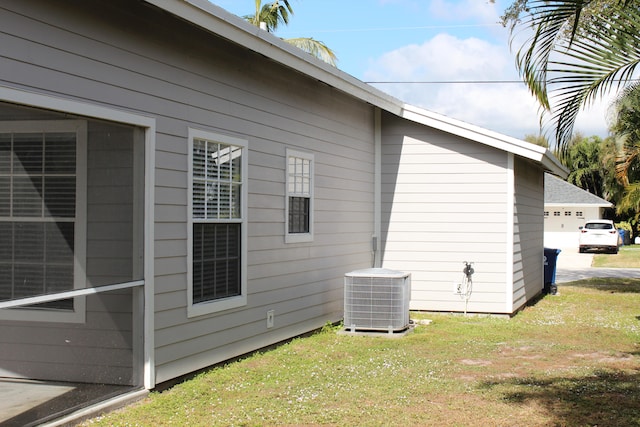 view of property exterior featuring central AC and a lawn