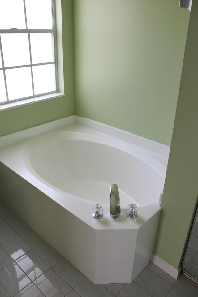 bathroom featuring tile patterned flooring and a tub to relax in