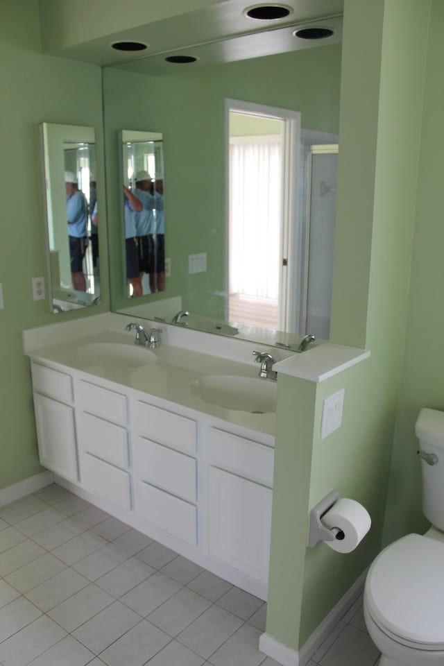 bathroom with walk in shower, tile patterned flooring, vanity, and toilet