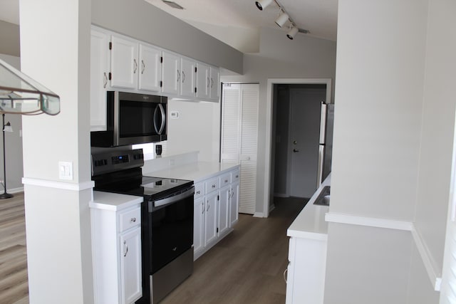 kitchen featuring dark hardwood / wood-style flooring, stainless steel appliances, white cabinetry, and rail lighting