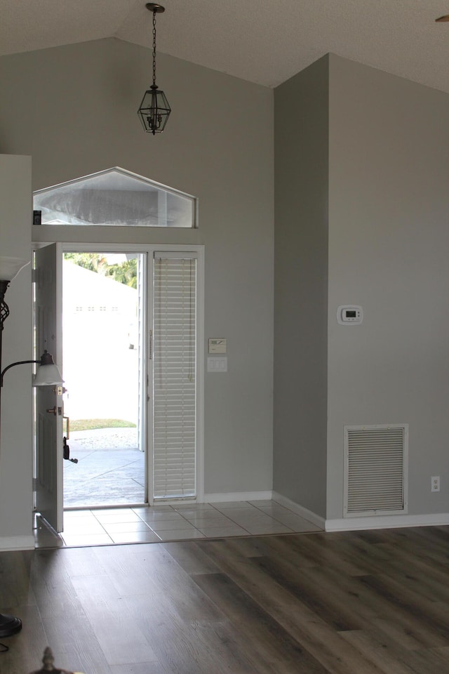 entryway with hardwood / wood-style floors and vaulted ceiling