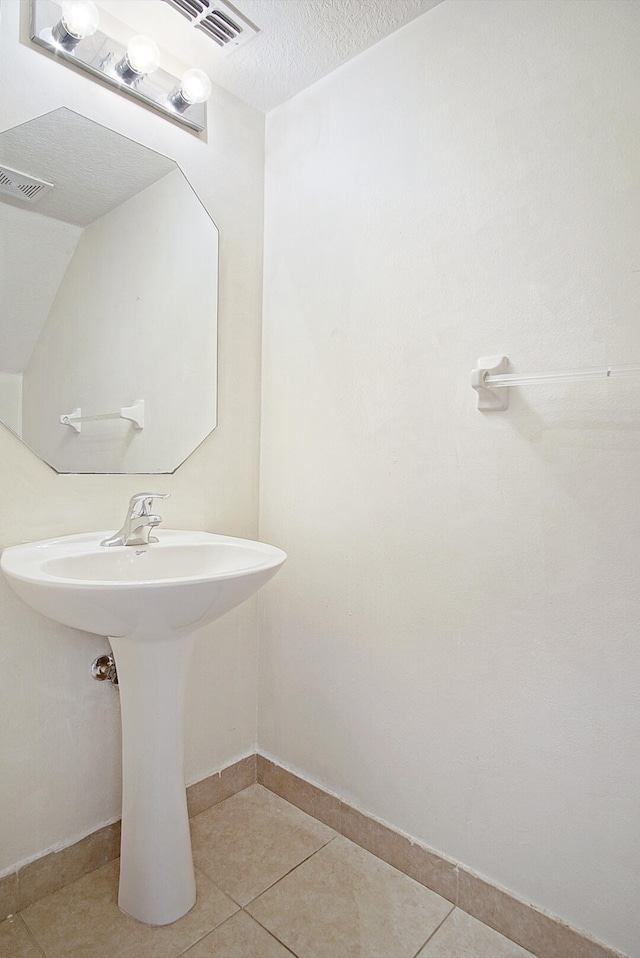 bathroom featuring tile patterned flooring, a textured ceiling, and sink