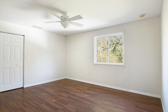 empty room featuring ceiling fan and dark hardwood / wood-style flooring