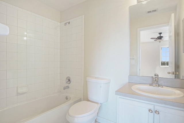 full bathroom featuring tiled shower / bath combo, ceiling fan, toilet, and vanity