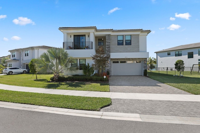 view of front of property featuring a balcony, a garage, and a front lawn