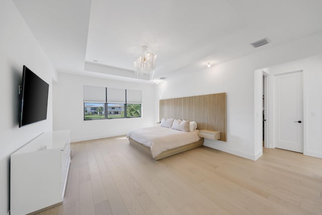 bedroom with light hardwood / wood-style flooring and a chandelier